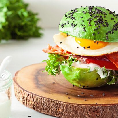 Lazy keto breakfast with eggs and bacon sandwiched inside an avocado